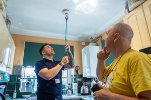 A Safe and Well officer testing a recently installed heat detector during a Home Fire Safety visit