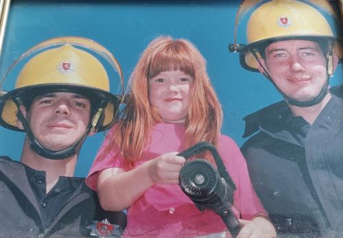 Elouise as a child with firefighters at Cranbrook