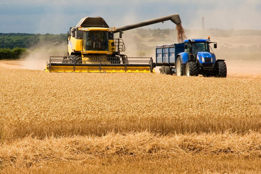 Combine and tractor in field