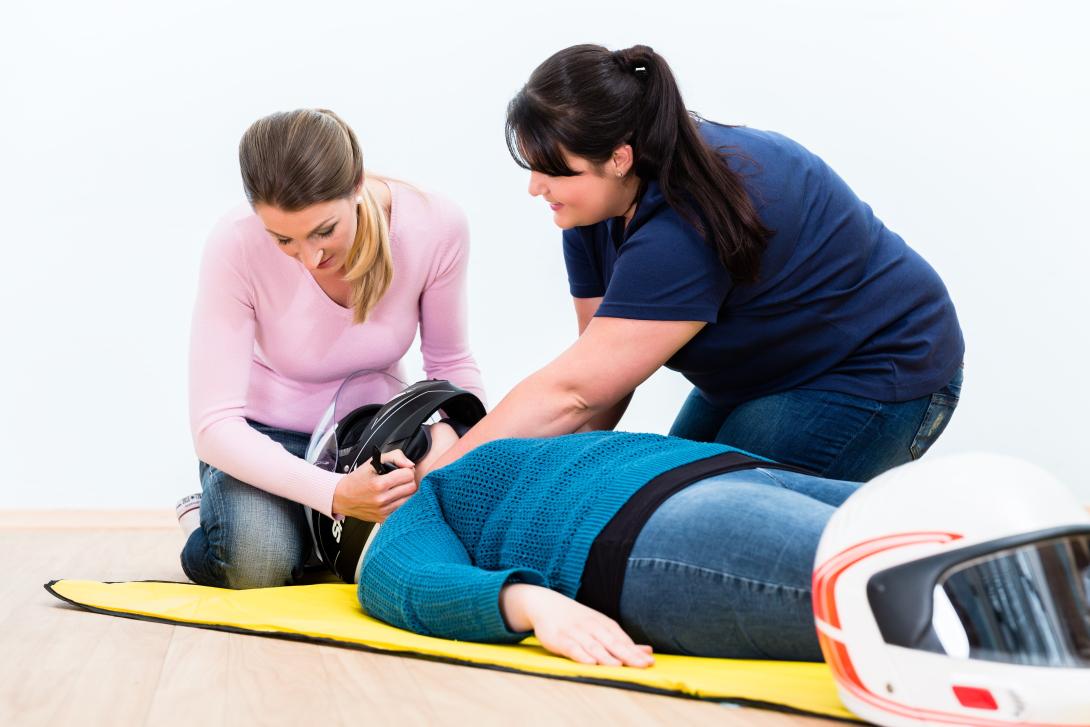 two people teaching crash helmet removal from casualty