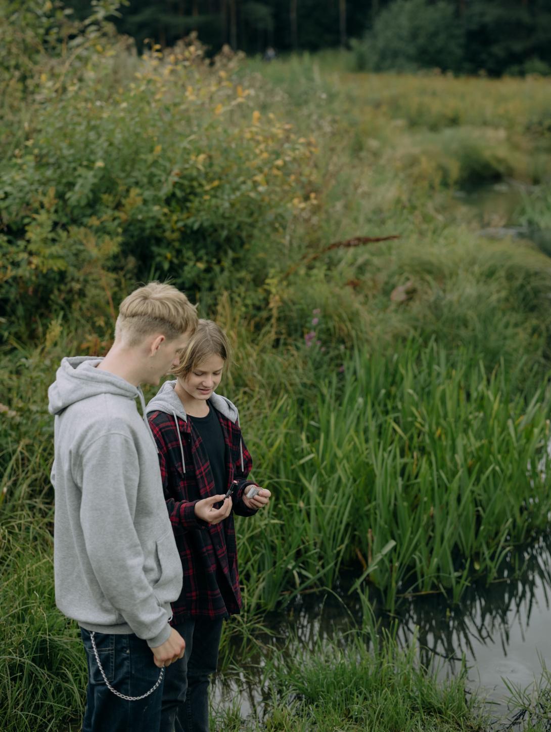 Two young people standing near water