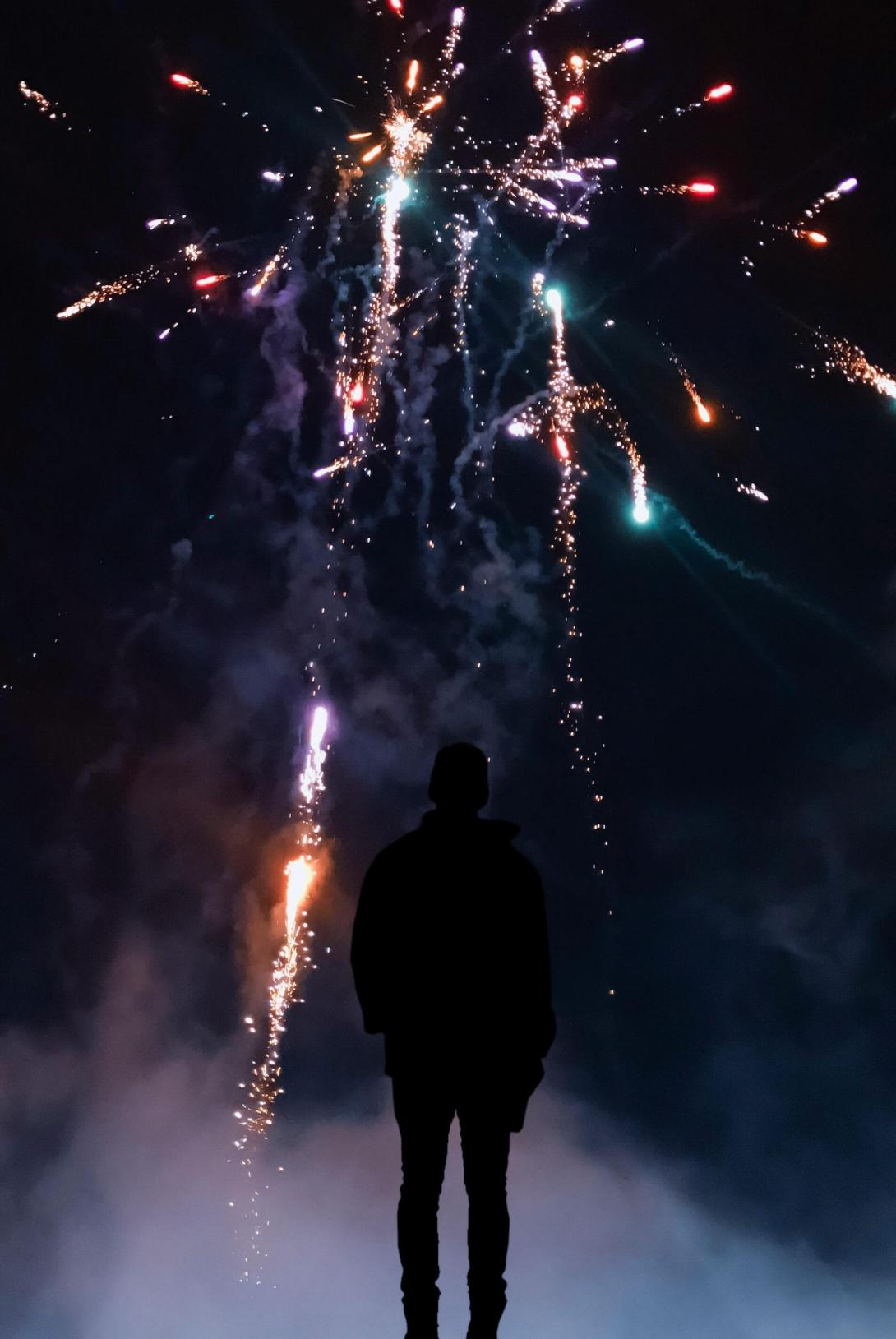 Silhouette of a young person watching fireworks